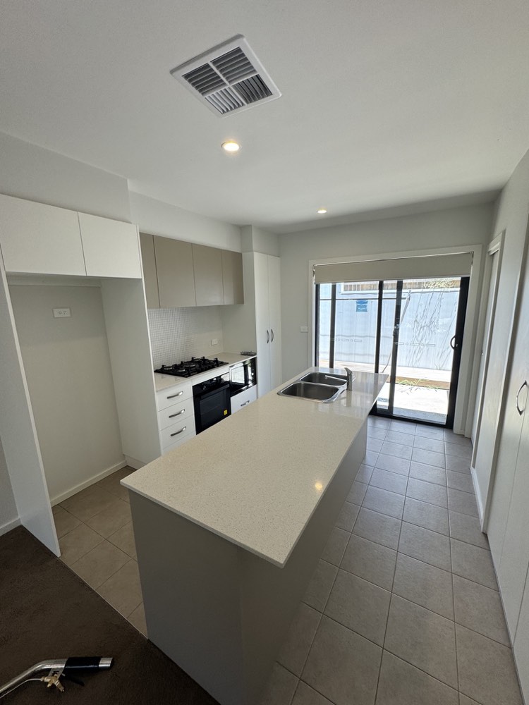 End of lease cleaned kitchen with clear benchtops and a polished island
